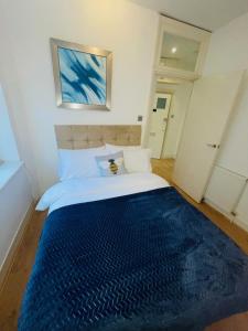 a bedroom with a large bed with a blue blanket at Amazing 2 bedroom apartment in London