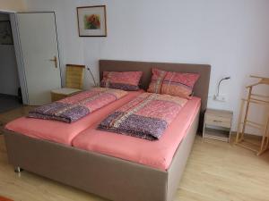 un lit avec des draps et des oreillers roses dans une chambre dans l'établissement Fewo FRIADO im Ferienpark OA - ohne Zusatzkosten nach Anreise - mit Hallenbad, W-Lan, PKW-Garage, Kurtaxe mit Allgäu-Walser-Pass, Bett- und Handtuch-Wäsche sowie End-Reinigung, à Missen-Wilhams 41 autres photos