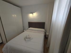 Cette petite chambre comprend 2 lits avec des draps blancs. dans l'établissement Formentera suite 13, à Es Pujols