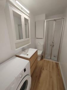 y baño con lavadora y lavamanos. en Formentera suite 13, en Es Pujols