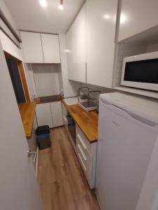- une petite cuisine avec des placards blancs et un four micro-ondes dans l'établissement Formentera suite 13, à Es Pujols