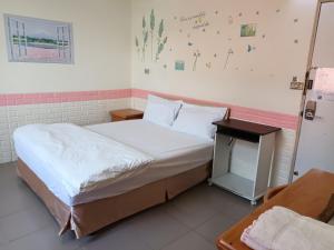 ein kleines Schlafzimmer mit einem Bett und einem Tisch in der Unterkunft Beido Qixing in Beidou