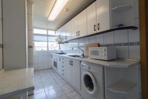 a kitchen with a washing machine and a microwave at Chipre IBERPLAYA in Salou