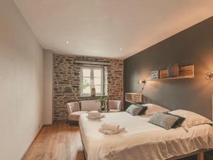 1 dormitorio con 1 cama grande y pared de piedra en Beautiful Cottage with Pool, en Ohey