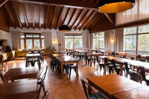 un restaurant avec des tables et des chaises en bois ainsi que des fenêtres dans l'établissement Hotel Golf Natura, à La Coma i la Pedra