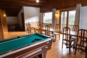 einen Billardtisch in einem Zimmer mit Tischen und Stühlen in der Unterkunft Hotel Golf Natura in La Coma i la Pedra