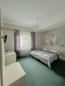 een slaapkamer met 2 bedden en een schilderij aan de muur bij Hotel Poleski in Krakau