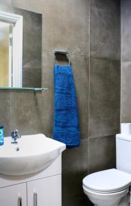 a bathroom with a white sink and a blue towel at Desire Residence in London