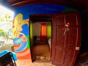 een kamer met een schilderij aan de muur en een deur bij Pirate and Mermaid Beach House in Puerto Viejo
