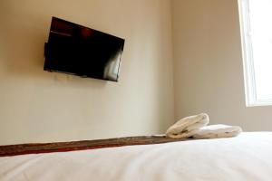 a bedroom with a bed with a tv on the wall at Art Cottage Hotel in Ipoh