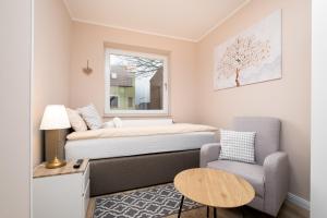 a small room with a bed and a chair and a table at Gästehaus "Kleines Stadtidyll" -Zimmer und Apartments by Hotel Holsteiner Hof- in Geesthacht