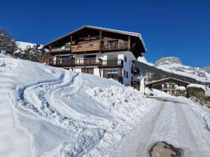 ein Gebäude auf einem schneebedeckten Berg mit einer Straße in der Unterkunft Appartement - Vue Mont-Blanc in Cordon