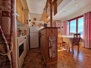 uma cozinha com uma mesa e um frigorífico branco em Appartement - Vue Mont-Blanc em Cordon