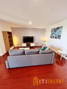 un soggiorno con divano e TV a schermo piatto di Spacious 1bd Penthouse - Close to ANU a Canberra
