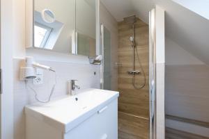a bathroom with a sink and a shower at Gästehaus "Kleines Stadtidyll" -Zimmer und Apartments by Hotel Holsteiner Hof- in Geesthacht