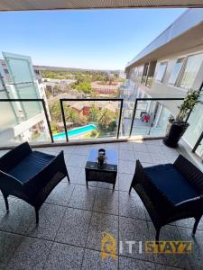 un balcone con 2 sedie e un tavolo su un edificio di Spacious 1bd Penthouse - Close to ANU a Canberra