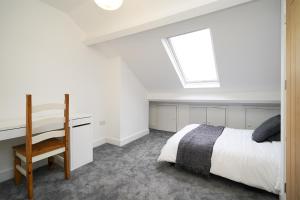 1 dormitorio con cama, escritorio y ventana en Charlotte House, entire private house, close to city centre, WiFi, en Sheffield