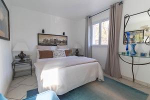 a white bedroom with a bed and a window at Villa Madiana -"La Perle" Villa piscine chauffée, Fitness proche Cannes, Fréjus, St Raphael, Grasse in Montauroux +50 photos