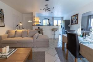 a living room and kitchen with a couch and a table at Villa climatisée, piscine privée chauffée, Fitness proche Cannes, Fréjus, St Raphael, Grasse in Montauroux