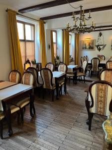 uma sala de jantar com mesas e cadeiras e um lustre em Gościniec Zamkowy em Darłowo