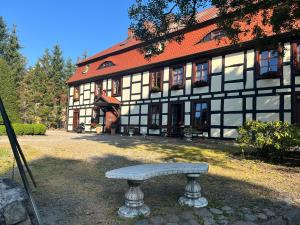 un banco de piedra frente a un edificio en Gościniec Zamkowy, en Darłowo