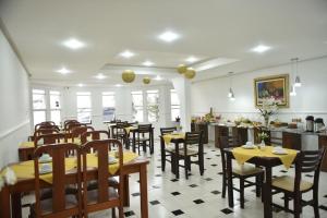 a dining room with tables and chairs in a restaurant at Pousada Normandy in São Lourenço