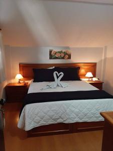 a bedroom with a bed with two white towels on it at Pousada Normandy in São Lourenço