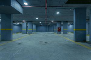 an empty parking garage with blue columns and lights at Land walk Hotel in Riyadh