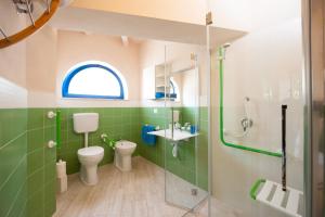 La salle de bains est pourvue de toilettes, d'un lavabo et d'une douche. dans l'établissement Villa Bruno, à Maruggio