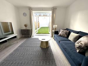 a living room with a blue couch and a table at Thorpe House - Home Crowd Luxury Apartments in Doncaster