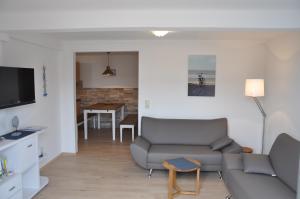 uma sala de estar com um sofá e uma mesa em Ferienhaus Nordstrand Whg 1 em Baltrum