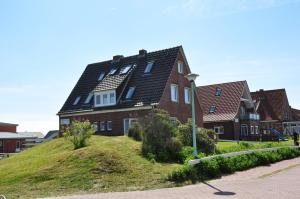 uma casa grande no topo de uma colina em Ferienhaus Nordstrand Whg 1 em Baltrum
