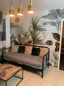 un sofá en una habitación con plantas en la pared en Ermont paris, en Ermont