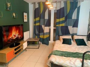 1 dormitorio con TV, 1 cama y 1 tvictericter en Ermont paris, en Ermont