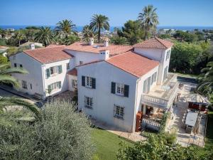 una vista aérea de una gran casa blanca con palmeras en LE BEAUVERT Belle Epoque luxury villa of 500 m2 with pool, en Antibes