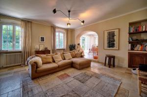 una sala de estar con un sofá marrón en una habitación en LE BEAUVERT Belle Epoque luxury villa of 500 m2 with pool, en Antibes