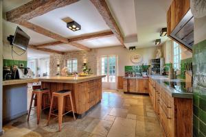 una gran cocina con armarios de madera y una gran isla en LE BEAUVERT Belle Epoque luxury villa of 500 m2 with pool, en Antibes