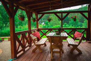 une terrasse en bois avec une table et des chaises. dans l'établissement Dom Farmerski w Górach Stołowych, à Radków