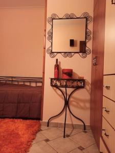 a room with a table with a mirror and a bed at VILLA ΚΟΡΑΛΙΑ in Tripolis