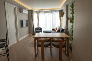 a living room with a wooden table and a dining room at Bolahenk Suites in Istanbul