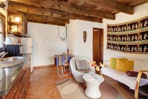 a kitchen and a living room with a couch at The Perfect Cottage in São Vicente