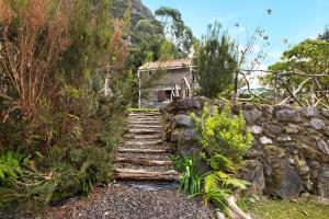a stone path leading up to a house on a mountain at The Perfect Cottage in São Vicente
