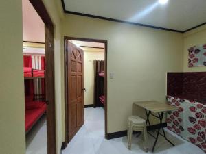 a room with a door and a table and a desk at 8-pax Jumongs Transient in Bantay