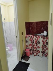 a bathroom with a toilet and a shower curtain at 8-pax Jumongs Transient in Bantay