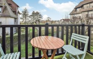 drewniany stół i 2 krzesła na balkonie w obiekcie Cozy Apartment In Blonville-Sur-Mer w mieście Blonville-sur-Mer