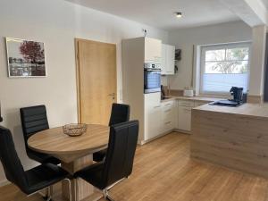 eine Küche und ein Esszimmer mit Tisch und Stühlen in der Unterkunft ByBesa in Winterberg