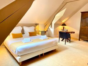 a bedroom with a bed with a desk and a piano at Domaine Utah Beach - Le Grand Hard in Sainte-Marie-du-Mont