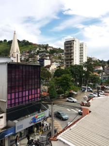 una ciudad con un edificio púrpura en una calle de la ciudad en Apartamento aconchegante no centro de Teresópolis ( várzea), en Teresópolis