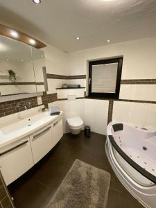 een badkamer met een bad, een toilet en een wastafel bij Hochheide Lodge in Winterberg