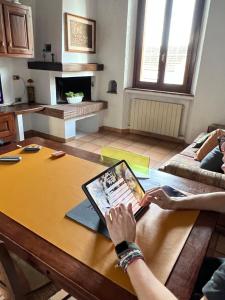 a person is sitting at a table with a tablet at CASA LUCIO in Grosseto